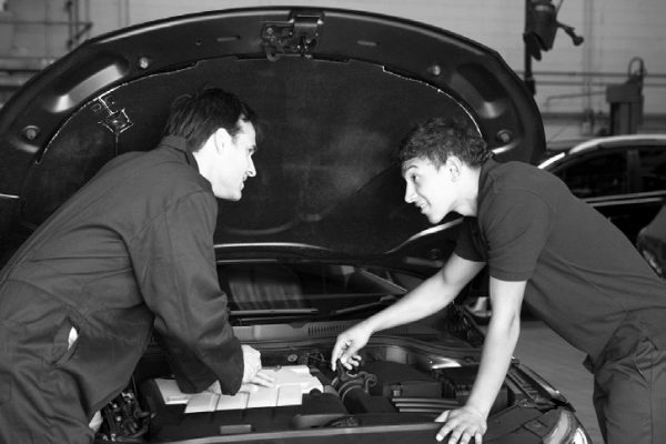 two men over car engine