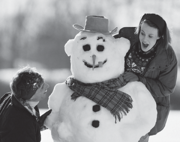 man and woman building snowman