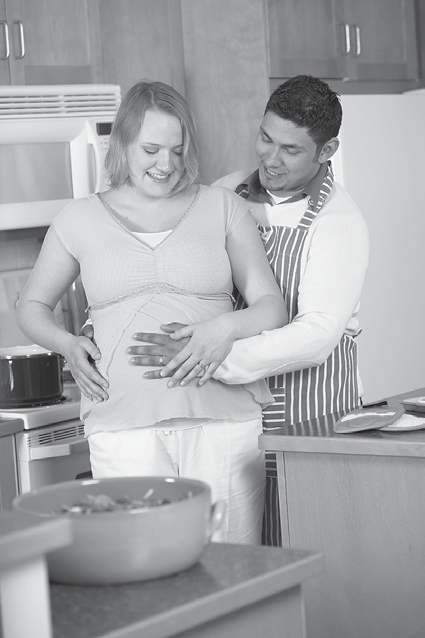 man with hand on pregnant woman's belly