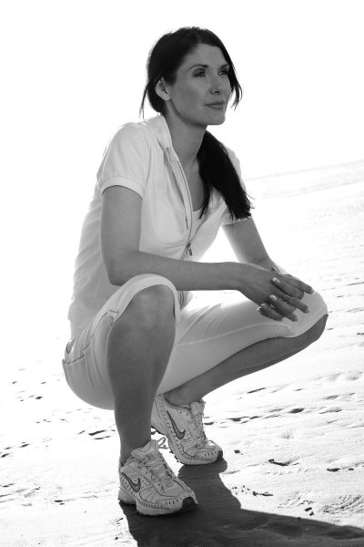 woman squatting on beach