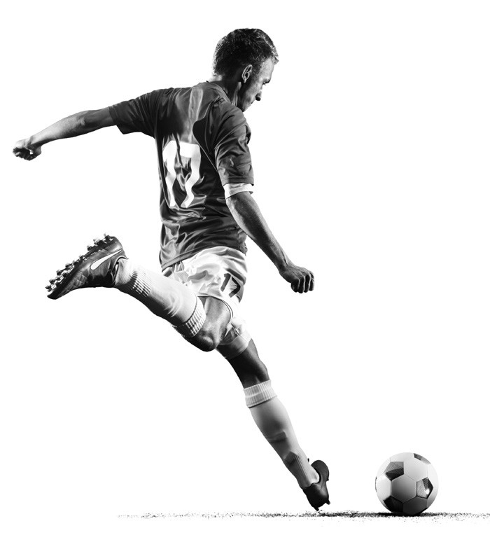 man kicking soccer ball