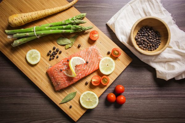 raw fish and vegetables on cutting board