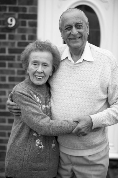 Elderly couple holding one another
