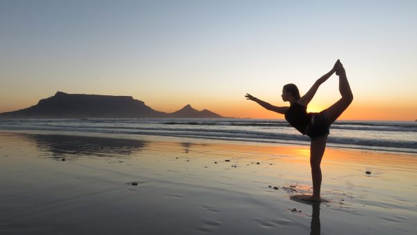 woman doing yoga on the beach